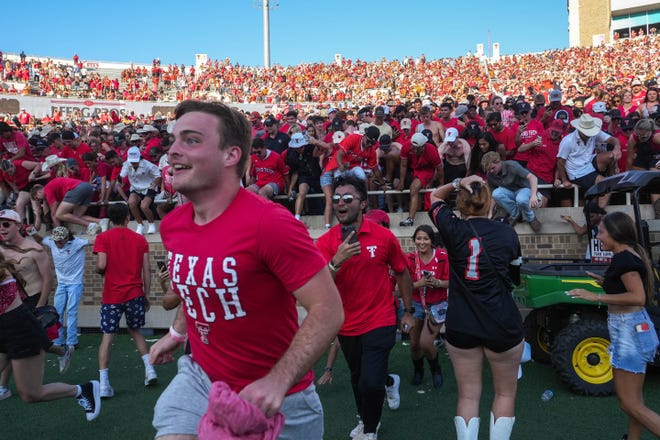 Texas Tech fans rush the field after Saturday's 37-34 victory over No. 22 Texas at Jones AT&T Stadium in Lubbock. It was the Red Raiders' first win over the Longhorns in Lubbock since 2008.