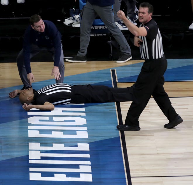 NCAA basketball official Bert Smith lies on the court after collapsing during the Gonzaga-USC men's game in the Elite Eight.